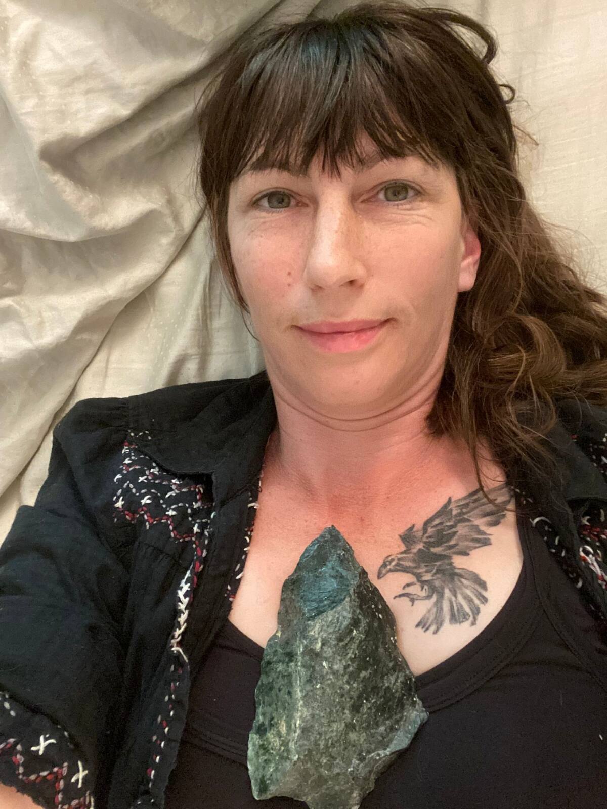 Kendra, founder of Wild Garden Medicinals, holding a piece of moss agate