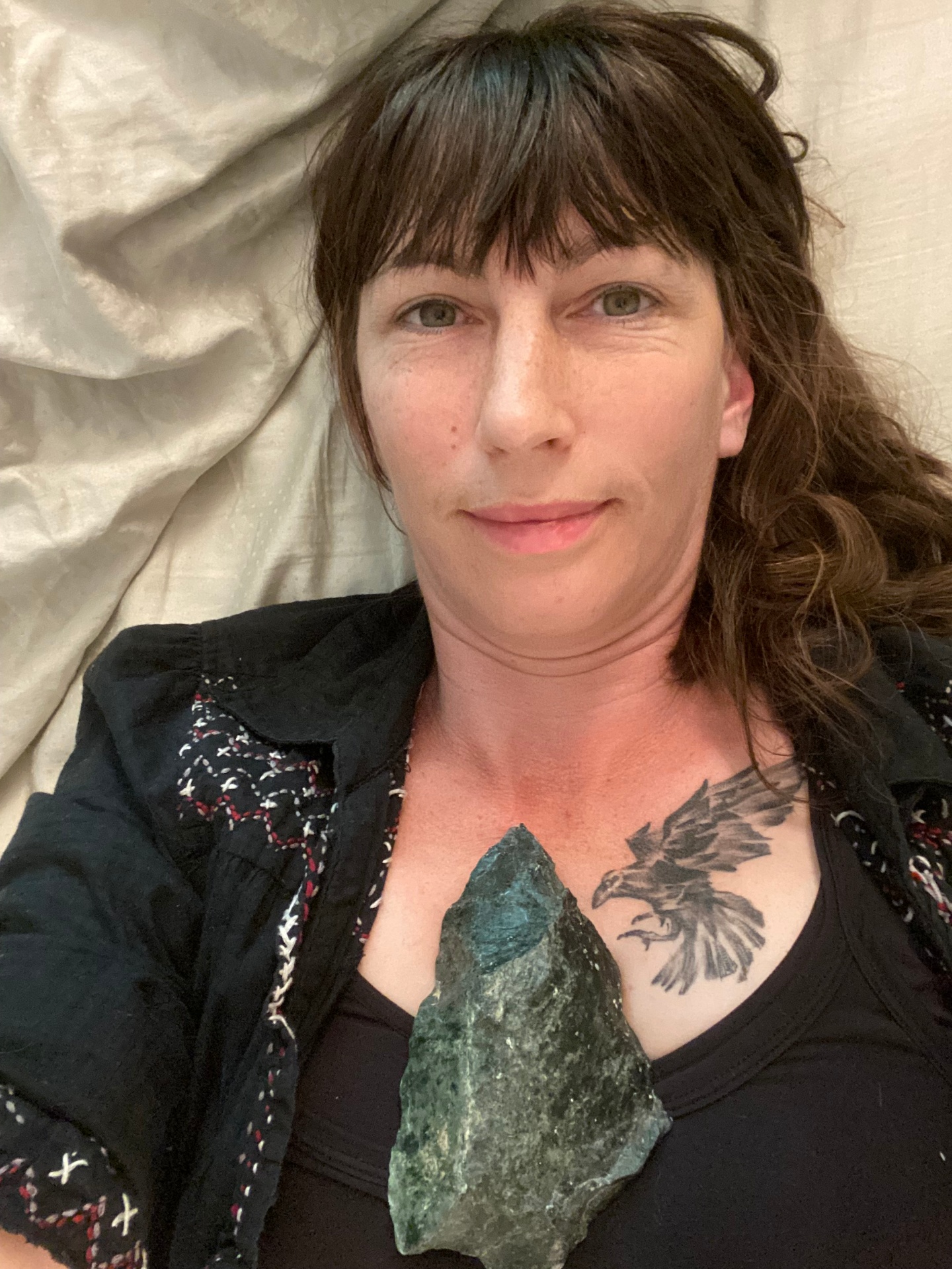 Kendra, founder of Wild Garden Medicinals, holding a piece of moss agate